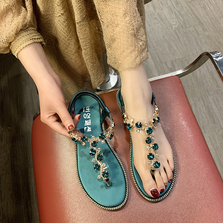 Women's flat T-strap sandals with sparkly jewelry chain, elastic heel strap, and padded footbed Mune Fashion
