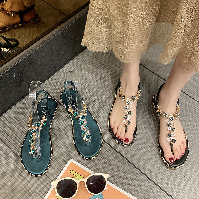 Women's flat T-strap sandals with sparkly jewelry chain, elastic heel strap, and padded footbed Mune Fashion