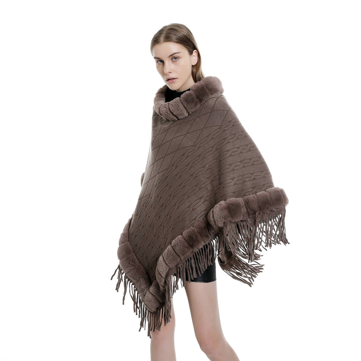 Women's wool look ruana with faux fur collar, fringed hem, and oversized drape.