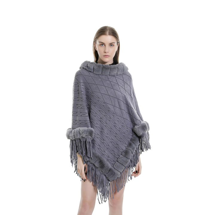 Women's wool look ruana with faux fur collar, fringed hem, and oversized drape.