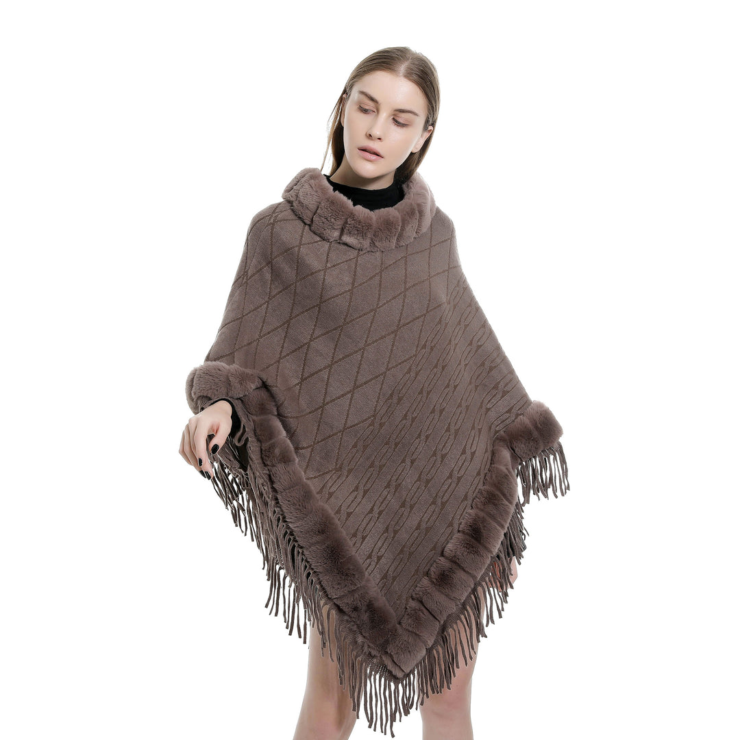 Women's wool look ruana with faux fur collar, fringed hem, and oversized drape.