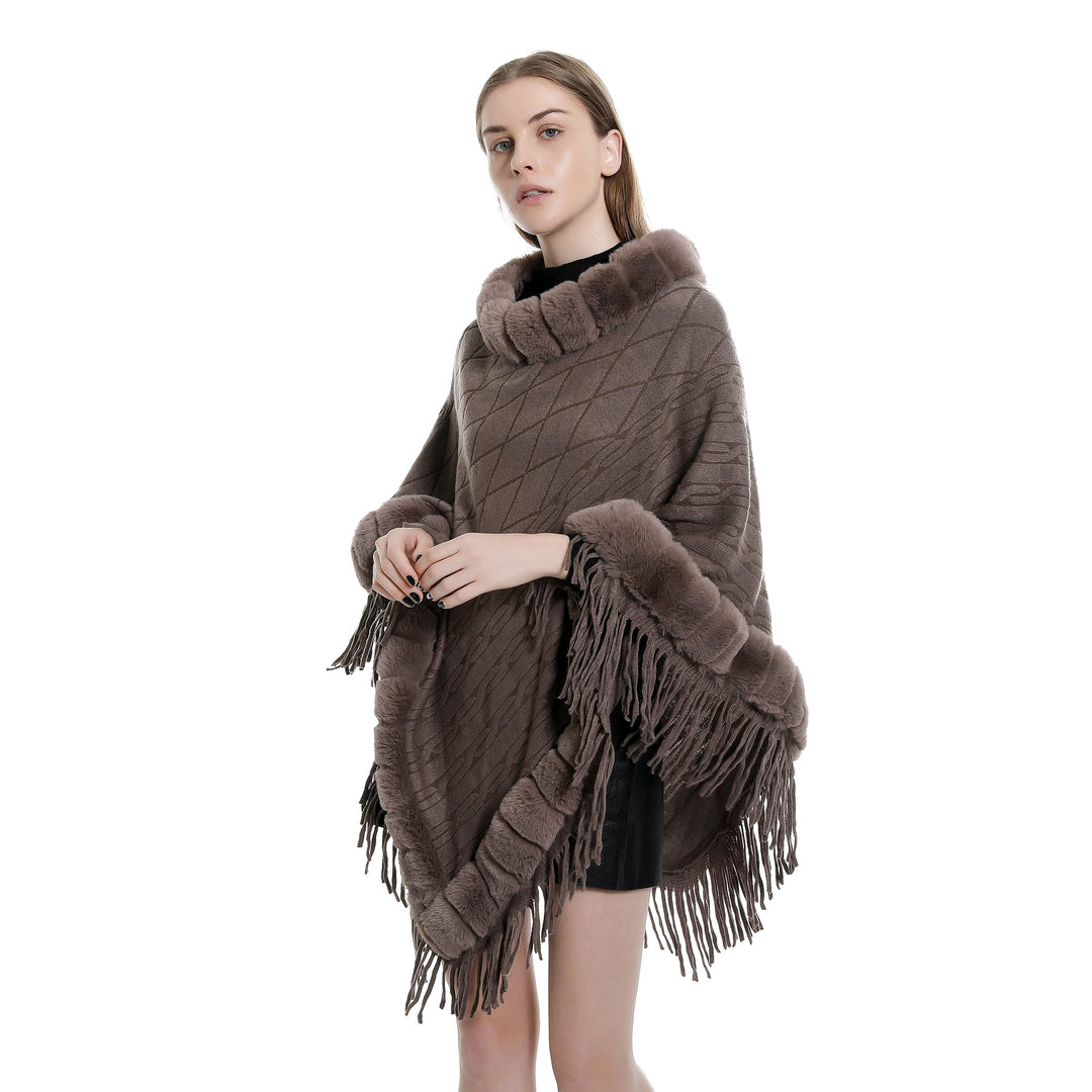 Women's wool look ruana with faux fur collar, fringed hem, and oversized drape.