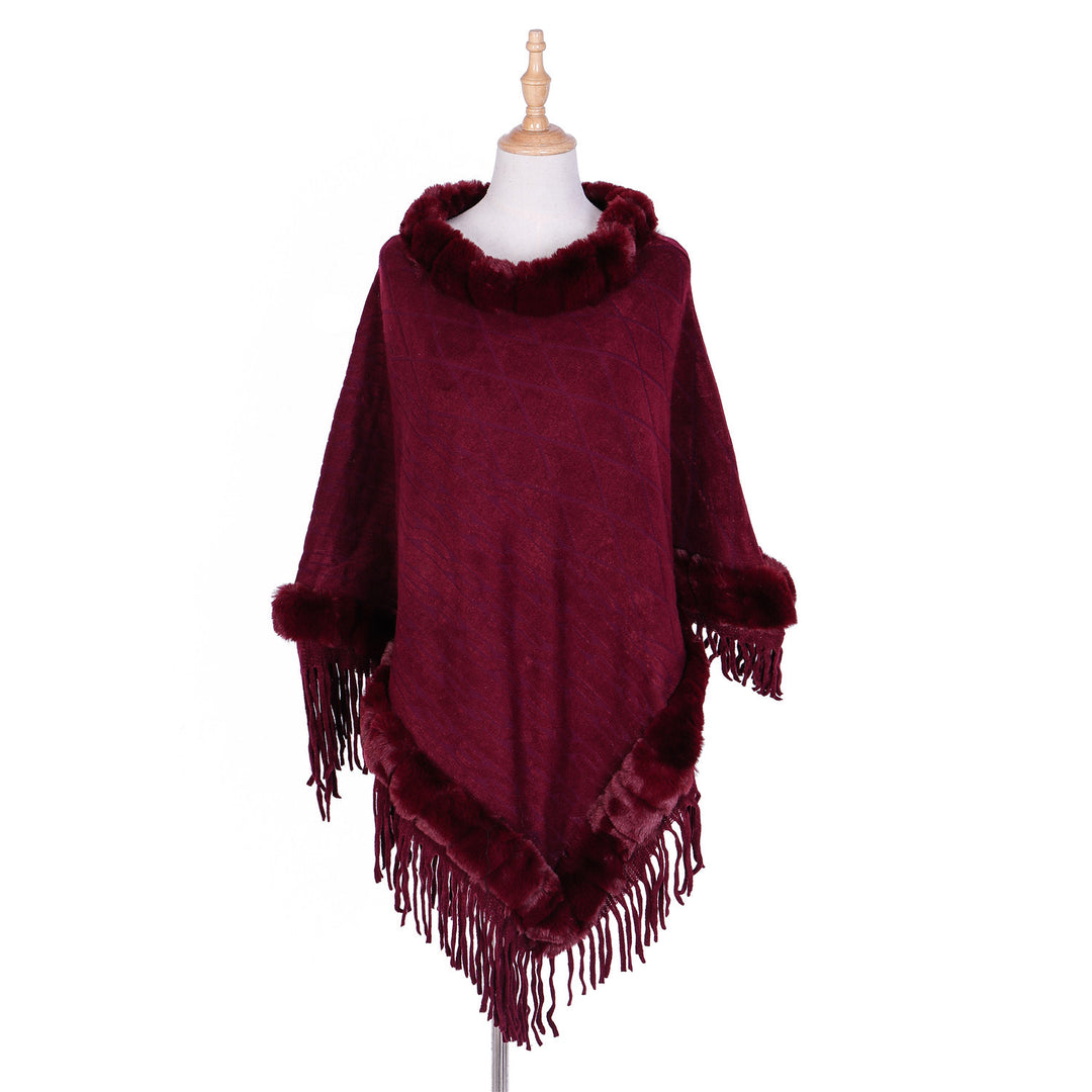 Women's wool look ruana with faux fur collar, fringed hem, and oversized drape.