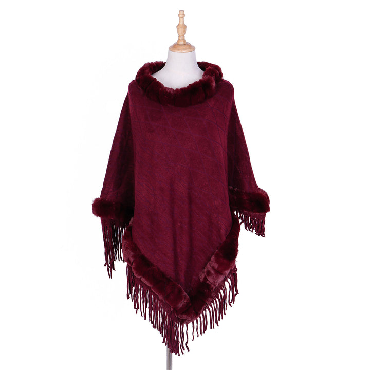 Women's wool look ruana with faux fur collar, fringed hem, and oversized drape.