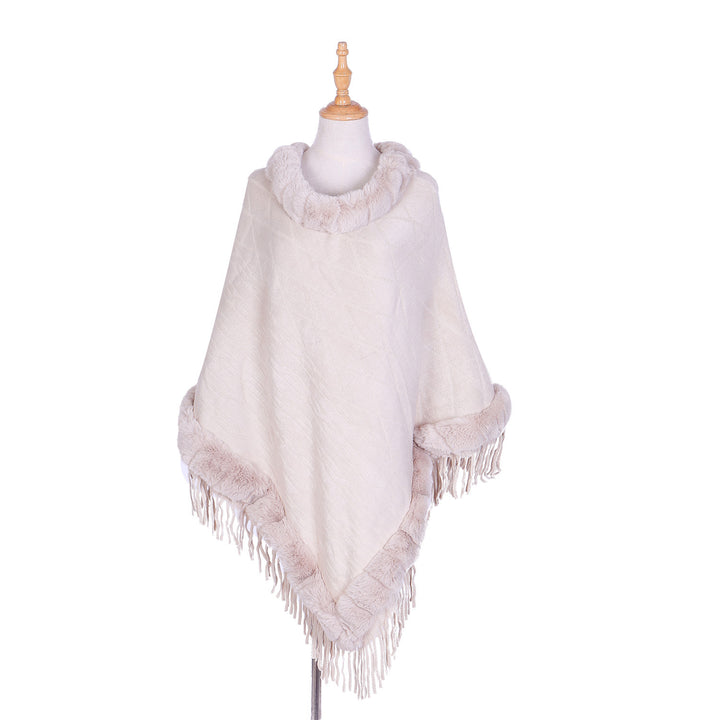 Women's wool look ruana with faux fur collar, fringed hem, and oversized drape.