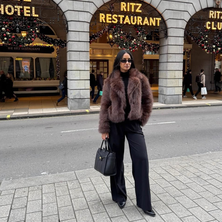 Fashionable women's faux fur coat in coffee brown