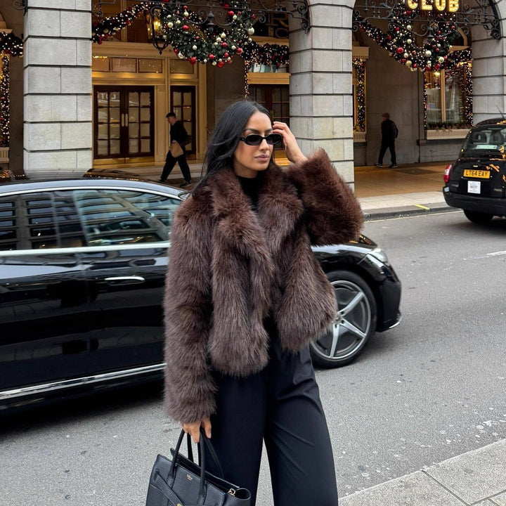 Fashionable women's faux fur coat in coffee brown