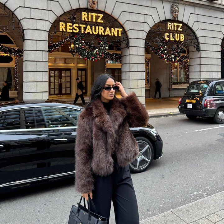 Fashionable women's faux fur coat in coffee brown