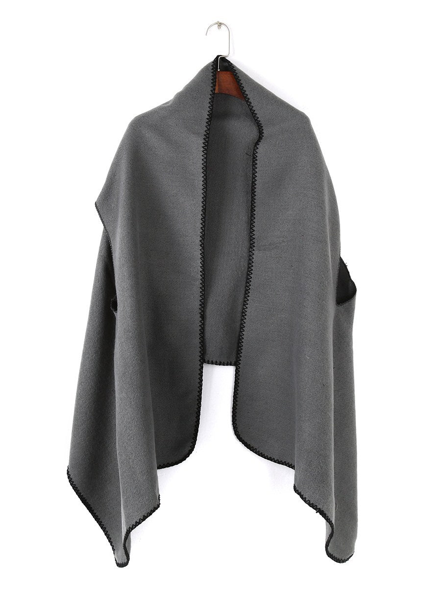 Women's oversized ruana poncho with arm openings and contrasting overlock stitching