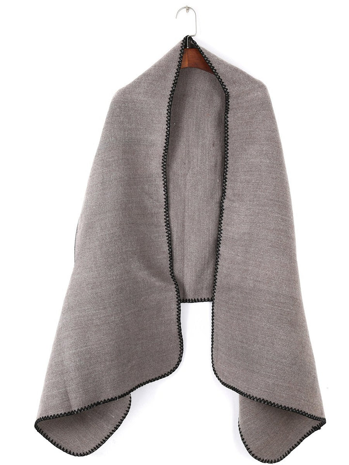 Women's oversized ruana poncho with arm openings and contrasting overlock stitching