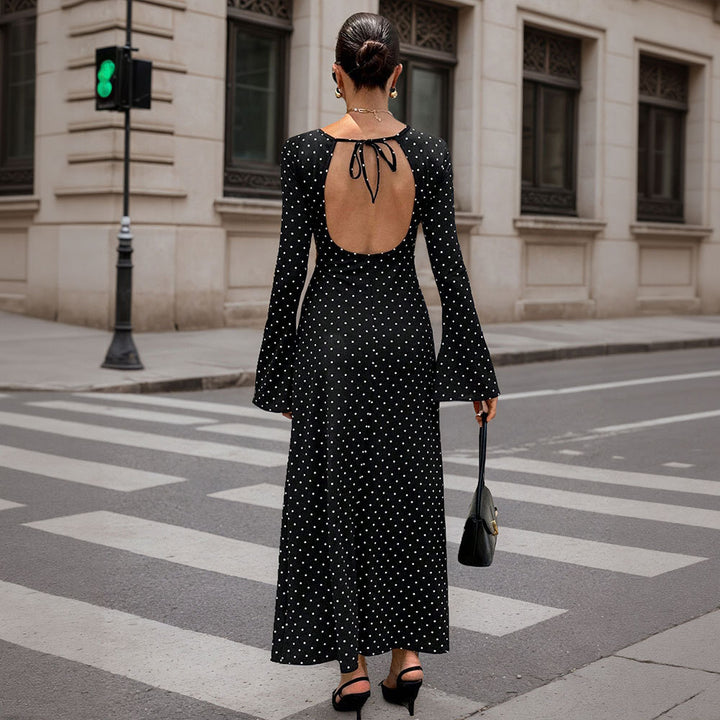 Women's elegant polka-dot maxi dress with fitted bodice, trumpet sleeves, and flowing A-line skirt.