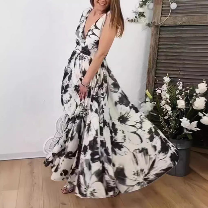 Women’s voluminous A-line maxi dress with deep V-neck, tailored tie belt and large floral brush print Mune Fashion