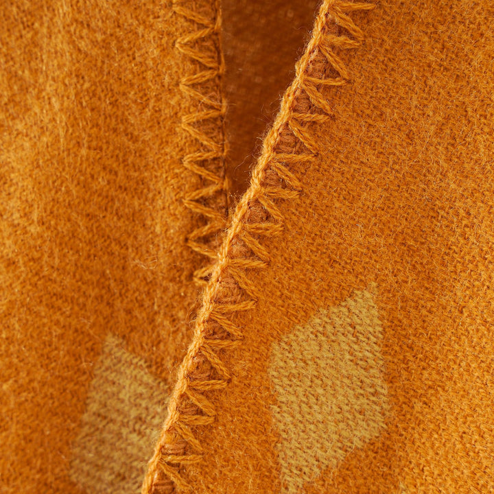 Women's oversized Ruana poncho with cashmere touch, geometric jacquard, and open kimono silhouette.