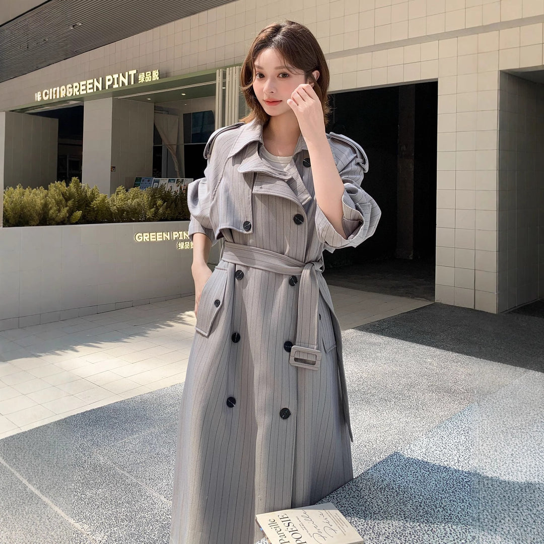 Women's long-cut pinstripe trench coat with voluminous sleeves, shoulder epaulettes, and tie belt Mune Fashion