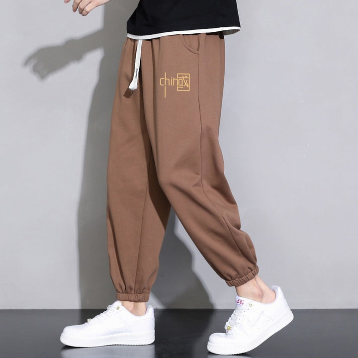 Men's loose fitting sweatpants with drawstring, elastic cuffs, and side pockets Mune Fashion