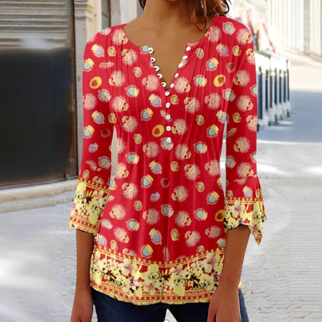 Women's flowing V-neck tunic with decorative button placket, chest pleats, three-quarter sleeves, and floral border edge Mune Fashion