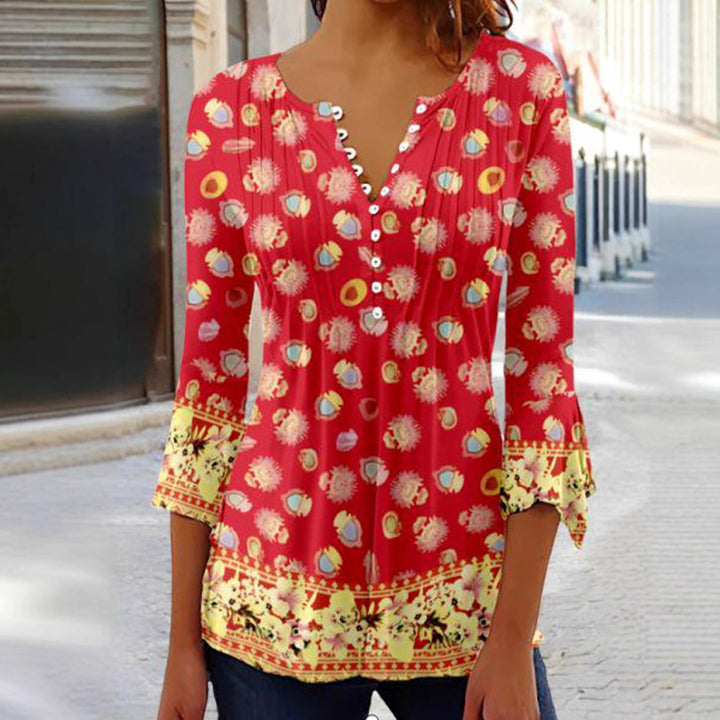 Women's flowing V-neck tunic with decorative button placket, chest pleats, three-quarter sleeves, and floral border edge Mune Fashion