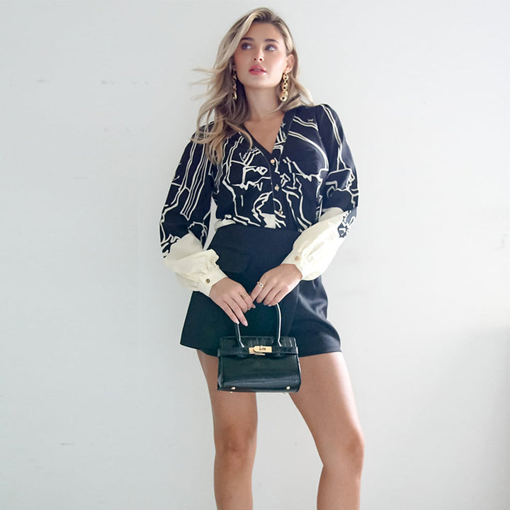 Women's V-neck blouse with abstract graphic print, balloon sleeves, and contrasting cuffs Mune Fashion