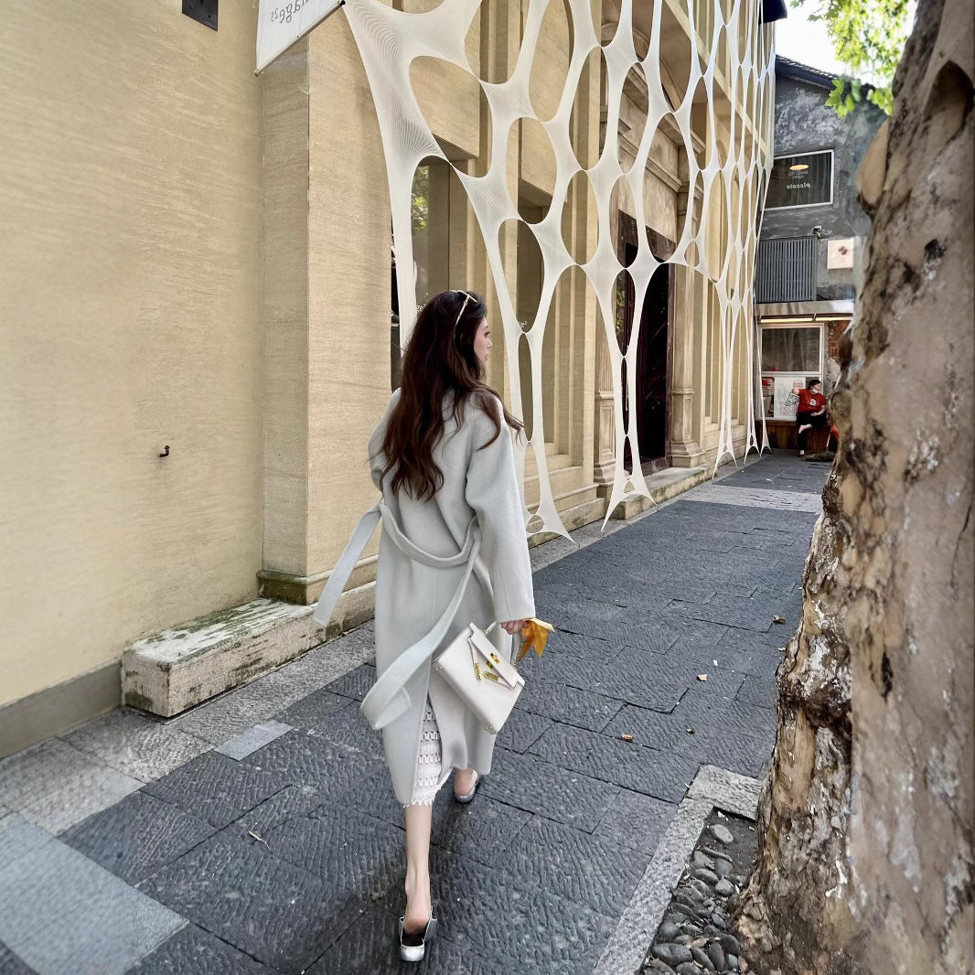 Women’s wool coat with double-breasted button placket, waist belt, and stand-up collar Mune Fashion