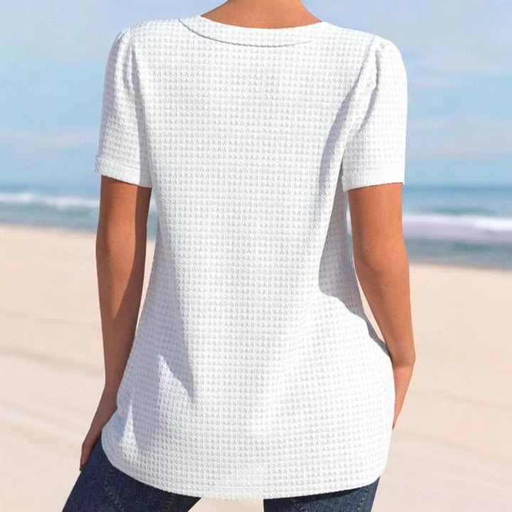Women's finely structured V-neck top with decorative button placket and slightly flared silhouette Mune Fashion