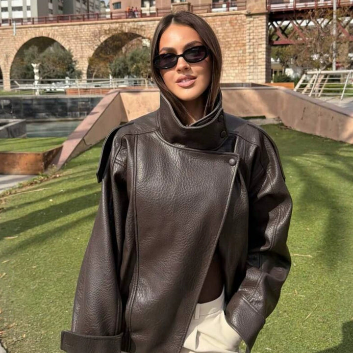 Ladies oversized biker jacket faux leather look with high stand-up collar, asymmetrical snap button front, shoulder straps and elastic hem Mune Fashion