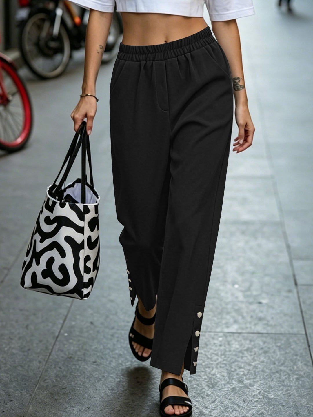 Women's loosely cut high-waist leisure pants with elastic waistband and decorative snap button placket on the leg Mune Fashion