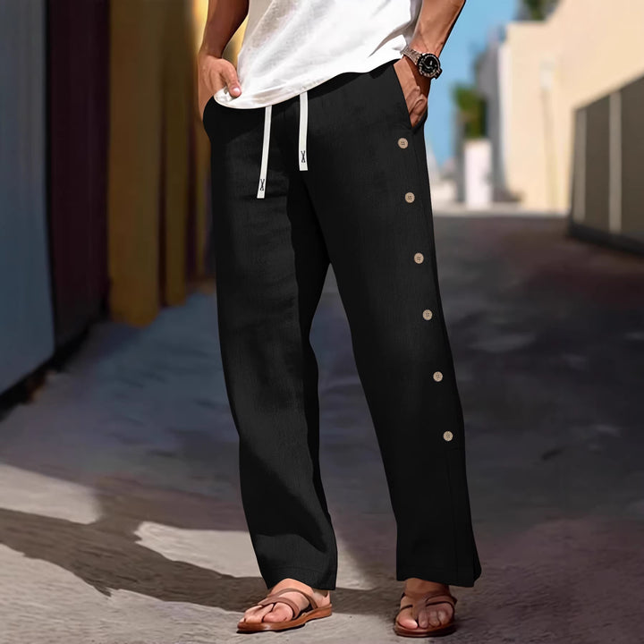 Men's loose leisure pants with side decorative button placket, drawstring waistband, and deep front pockets Mune Fashion