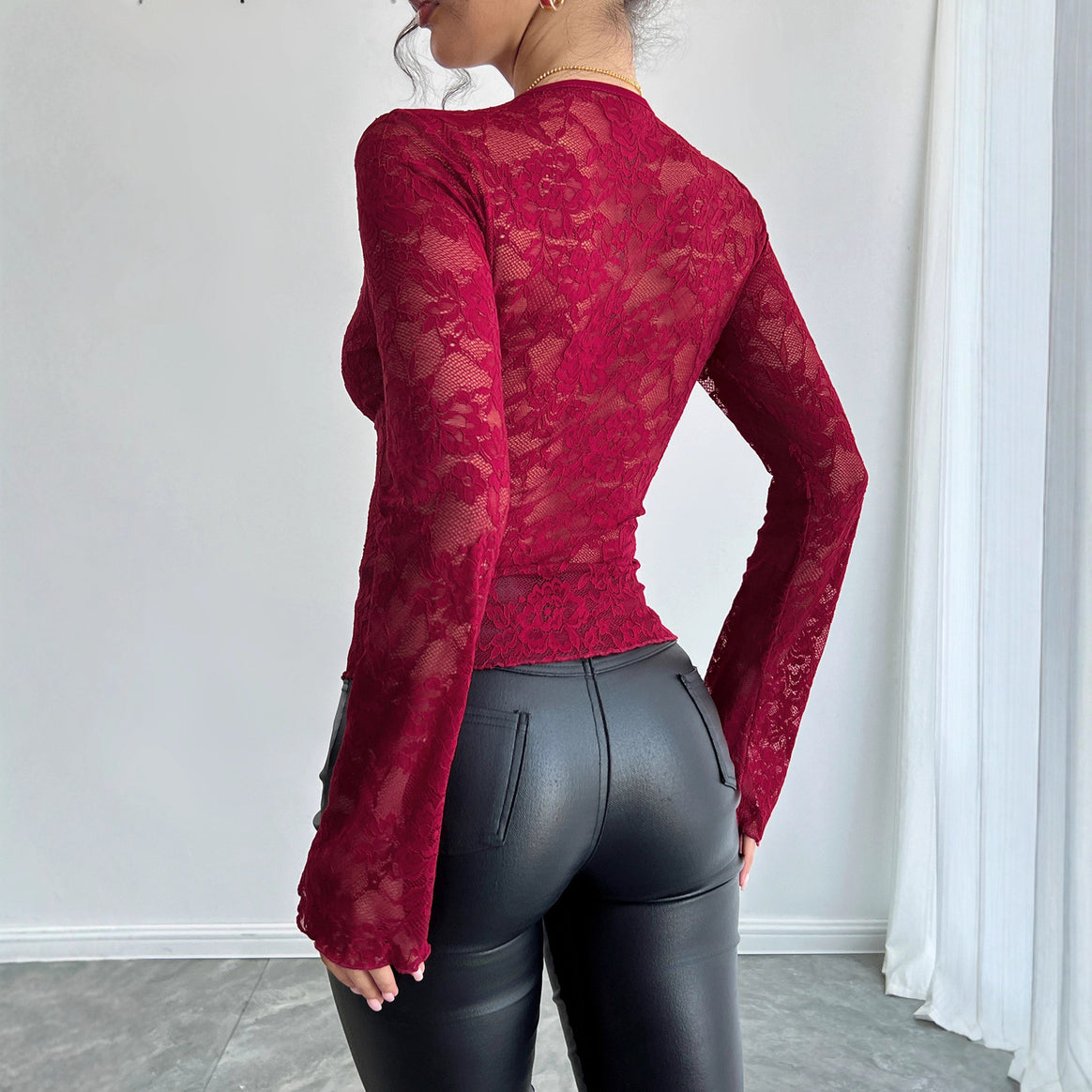 Women's fitted lace long-sleeve top with curved V-neckline, floral transparency, and flared cuffs Mune Fashion