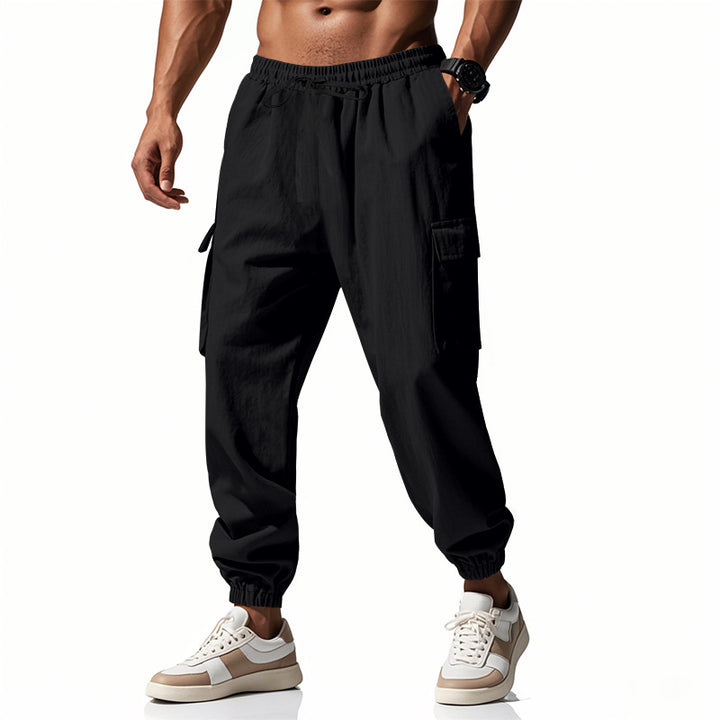Men's tapered joggers in utilitarian style with elastic waistband, drawstring, and flap pockets Mune Fashion