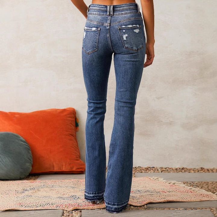 Ladies high-waisted vintage bootcut jeans with double button fly, light destroyed detail, and frayed hem Mune Fashion
