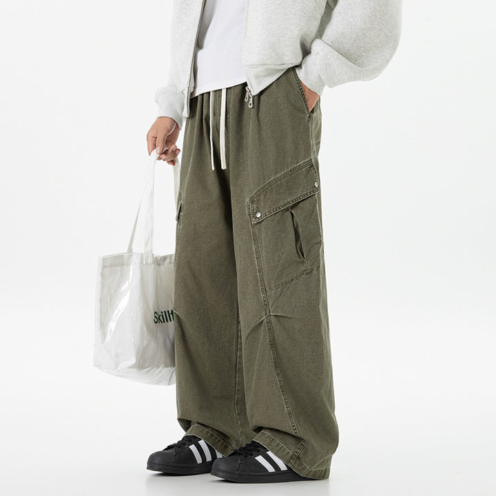 Men's loose utility cargo pants in baggy cut with drawstring waistband and large flap pockets.
