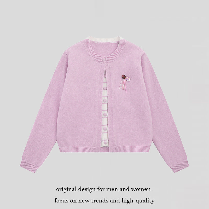 Ladies fine knit cardigan with round neckline, concealed button placket, and decorative brooch Mune Fashion
