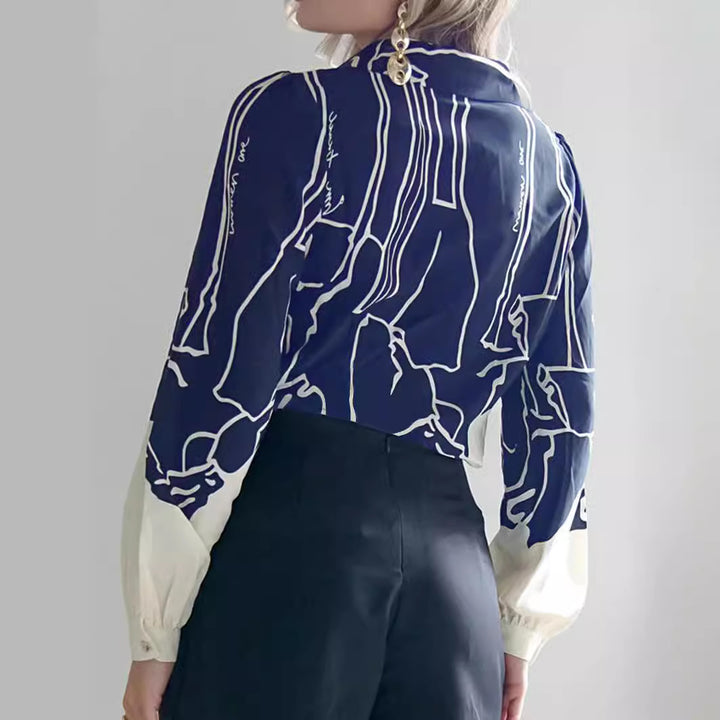 Women's V-neck blouse with abstract graphic print, balloon sleeves, and contrasting cuffs Mune Fashion