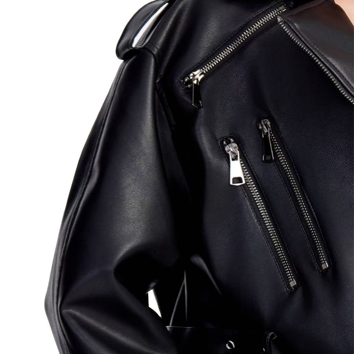 Ladies short fitted biker jacket made of faux leather with double waist belt, epaulettes and zipper details Mune Fashion