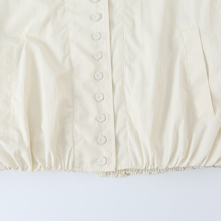 Women's cropped blouson jacket with stand-up collar, continuous decorative button placket and elastic hem.