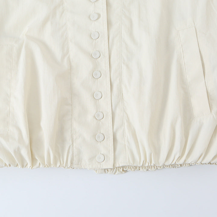 Women's cropped blouson jacket with stand-up collar, continuous decorative button placket and elastic hem.