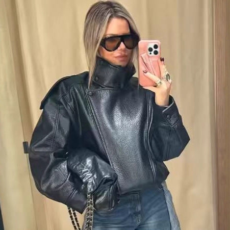 Women's oversized faux leather jacket with high standing collar, asymmetric button placket, shoulder flaps, and elastic hem Mune Fashion