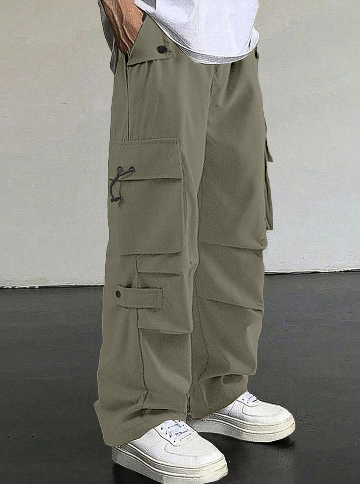 Men's baggy cargo pants with utilitarian flap pockets, drawstring waistband, and reinforced seams Mune Fashion