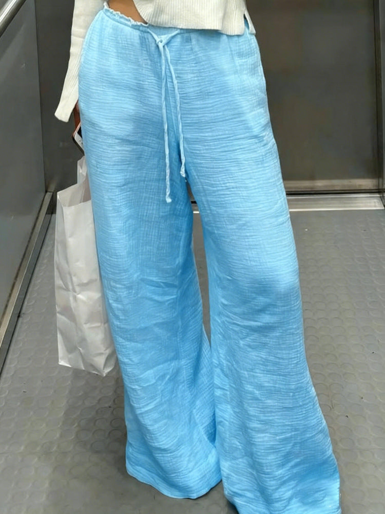 Women's linen trousers with a relaxed, ankle-length fit, side pockets and decorative button details Mune Fashion