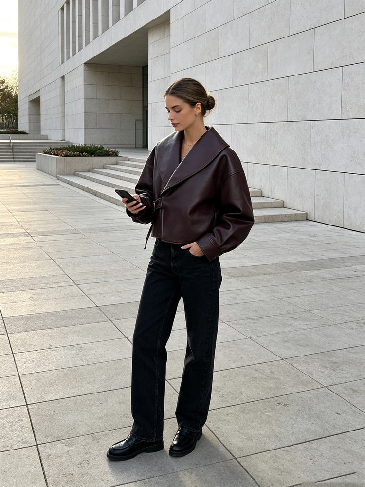Women's short jacket made of synthetic leather with side buckle waist and voluminous raglan sleeves Mune Fashion