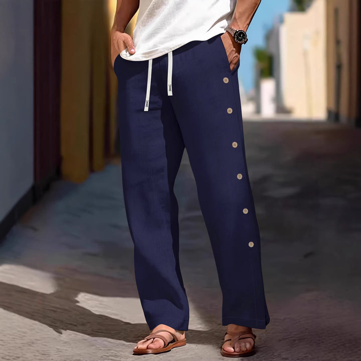 Men's loose leisure pants with side decorative button placket, drawstring waistband, and deep front pockets Mune Fashion