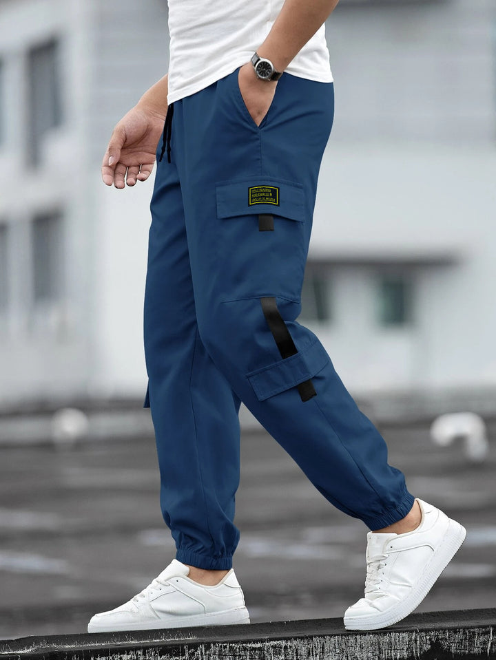 Men's fashionable cargo jogger pants with elastic waistband, drawstring, and multiple security and flap pockets Mune Fashion