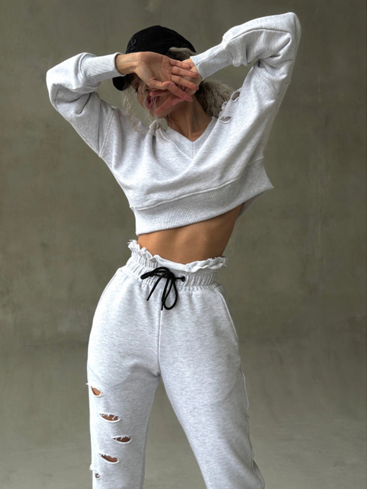 Ladies short-cut sweat set with V-neck, ruffled waistband high-waist joggers and distressed details Mune Fashion