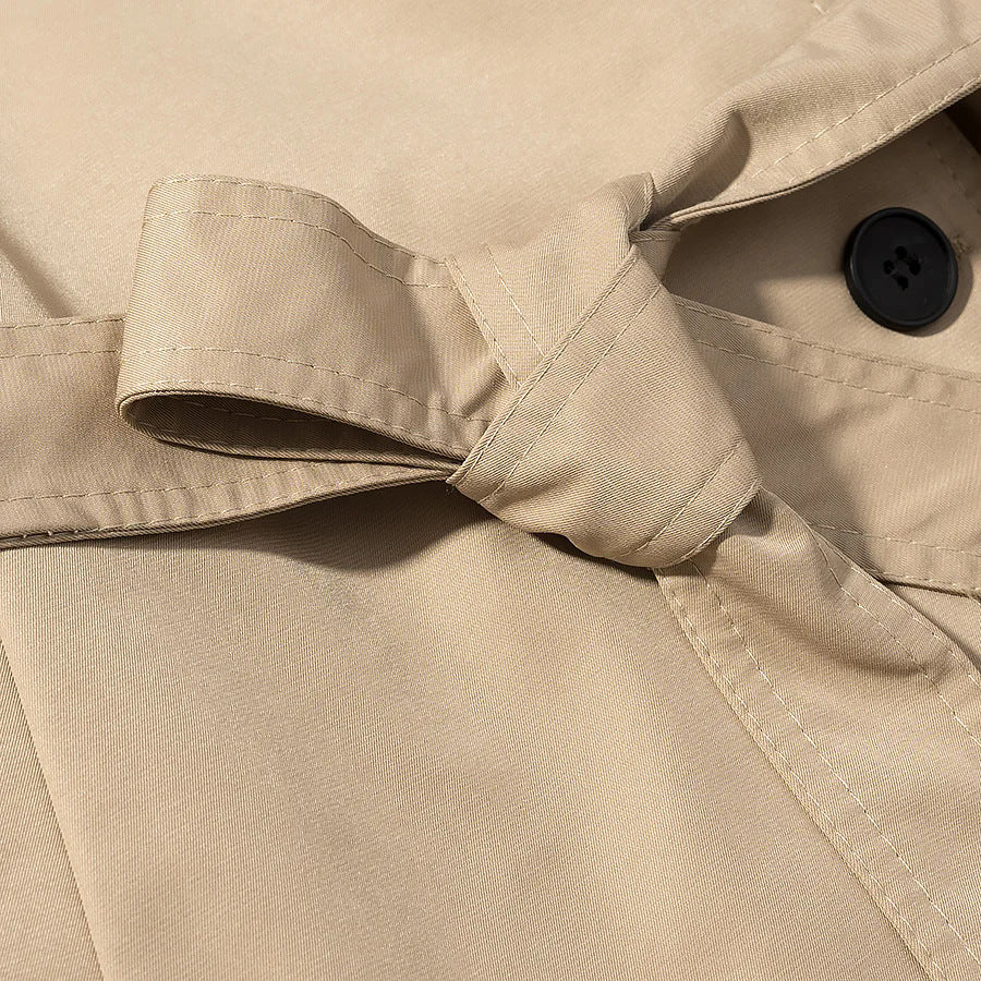 Women's short utility trench coat with stand-up collar, double-layered button placket, shoulder flaps, and fitted tie belt Mune Fashion