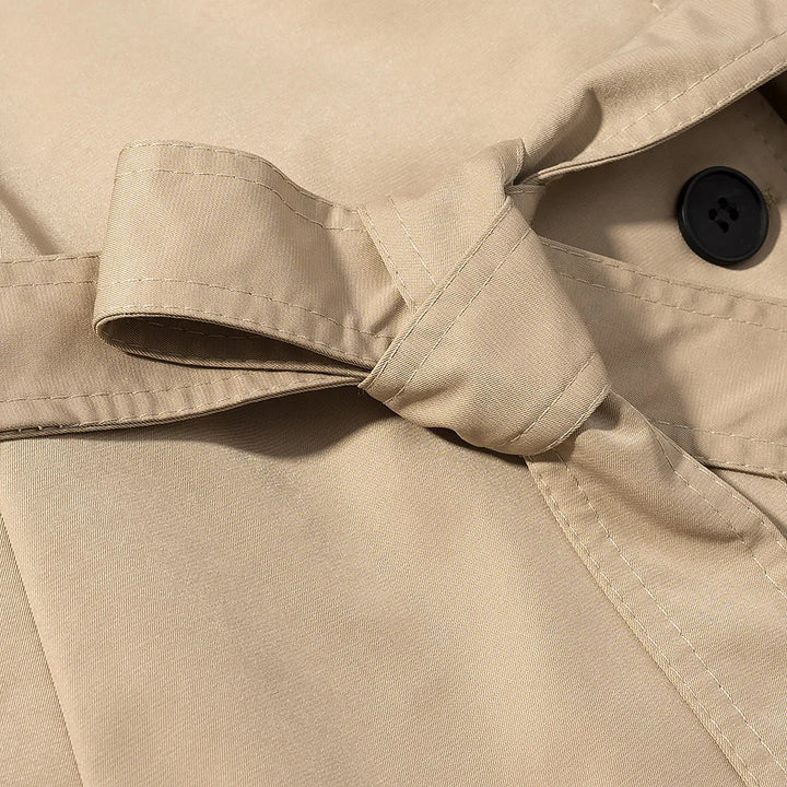 Women's short utility trench coat with stand-up collar, double-layered button placket, shoulder flaps, and fitted tie belt Mune Fashion