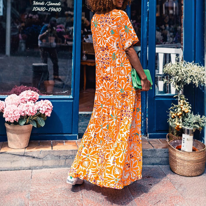 Women’s ankle-length V-neck maxi dress with graphic ethnic print, short sleeves and flared ruffle hem Mune Fashion