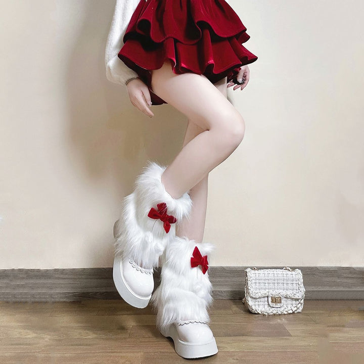 Ladies cozy boot cuffs made of faux fur with bow appliqué and pompons Mune Fashion