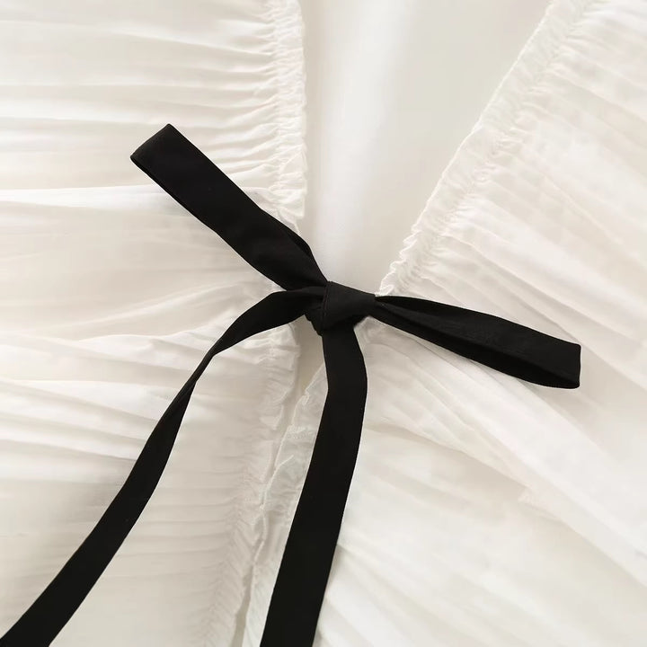 Ladies sleeveless ruffle blouse with deep V-neck, delicate pleated ruffle and tie bow detail