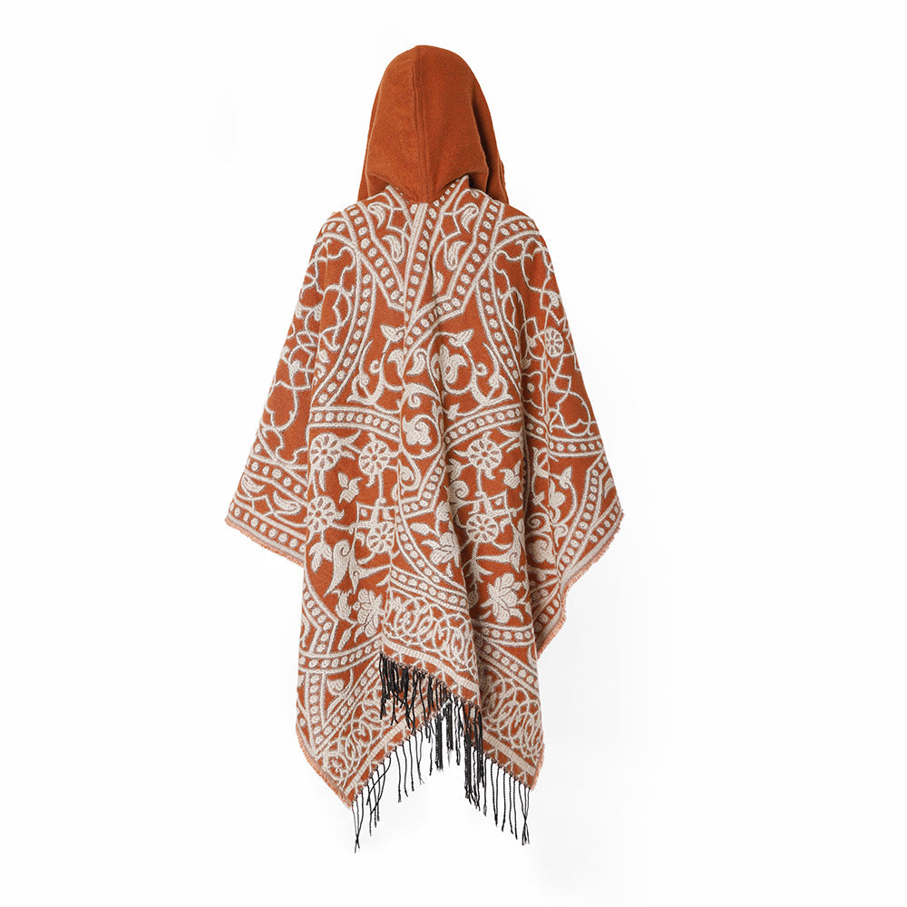 Women’s hooded cape poncho made of wool blend with jacquard pattern, fringes and oversized drape.