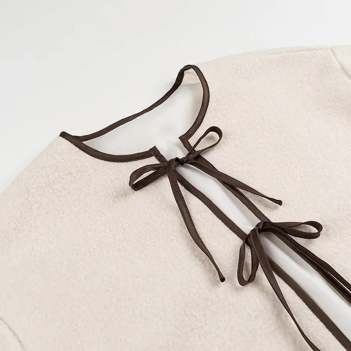 Women short-cut teddy jacket with double-tied bow closure, round neck and contrast piping Mune Fashion